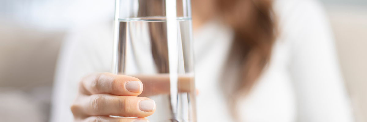 women holding a glass of water