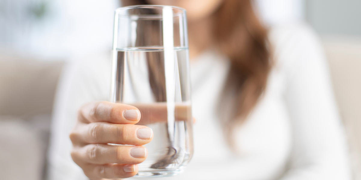 women holding a glass of water